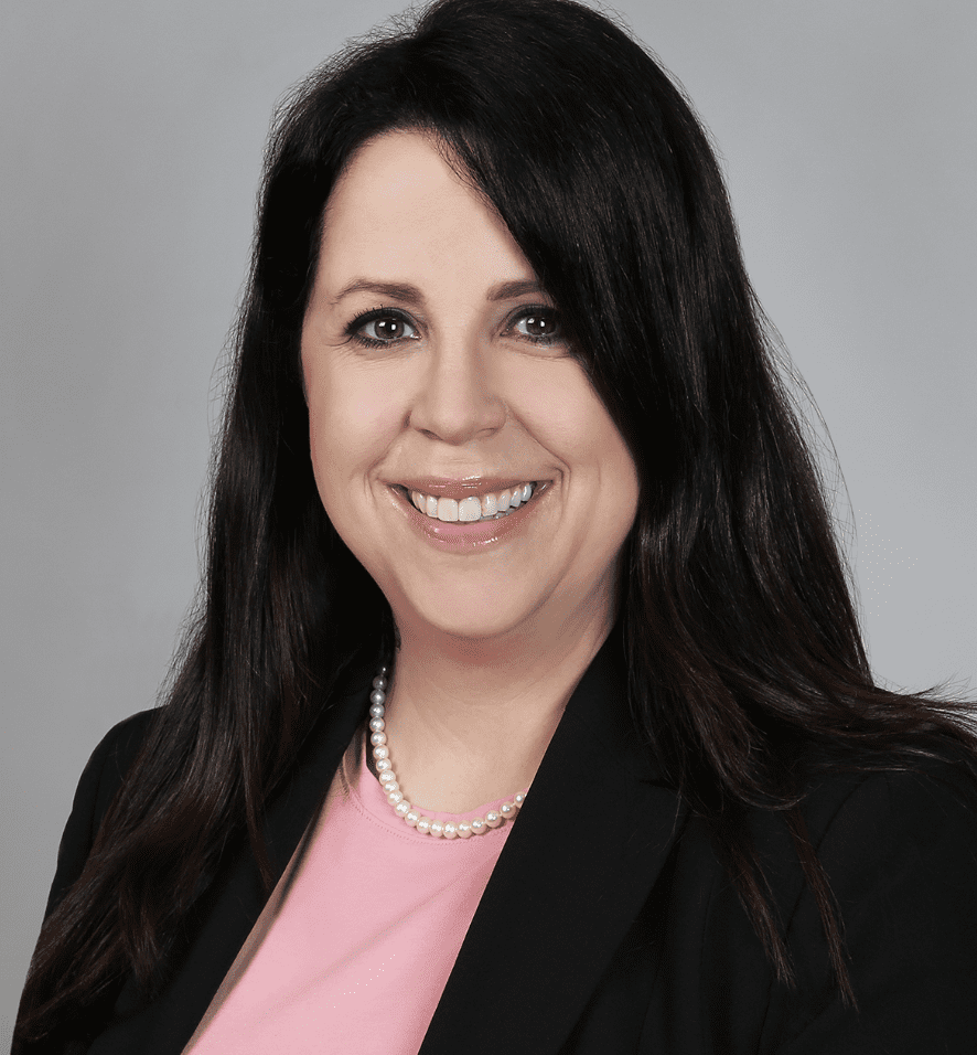 A woman in black jacket and pink shirt.