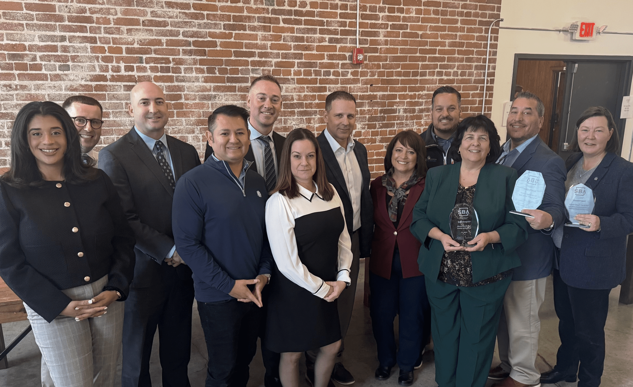 A group of people standing in front of a brick wall.