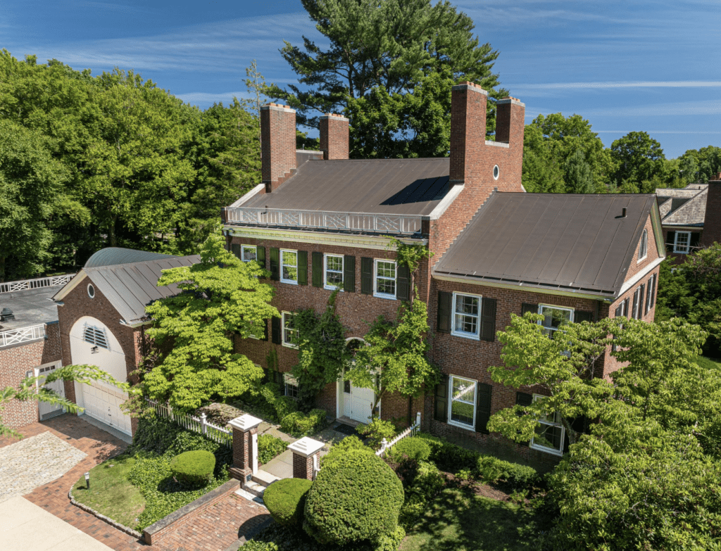 A large brick house with trees in the background.