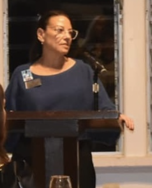 A woman standing at a podium with a microphone.