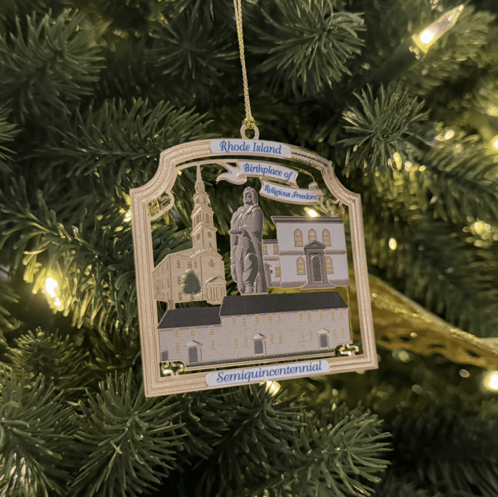 A christmas ornament hanging from the side of a tree.