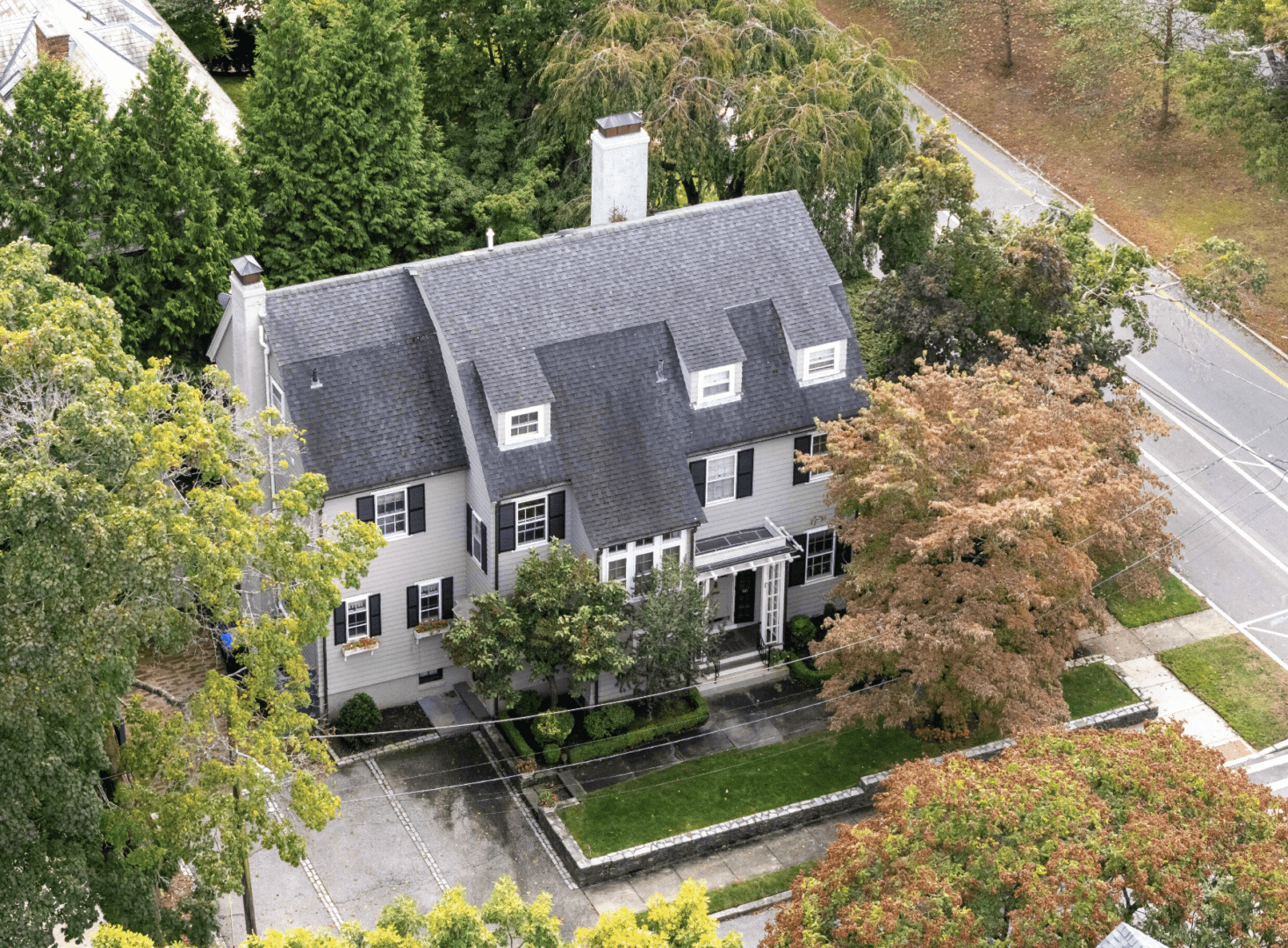 A large white house with trees in the background