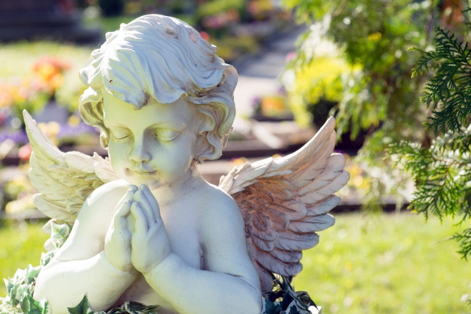 A statue of an angel with hands in prayer.