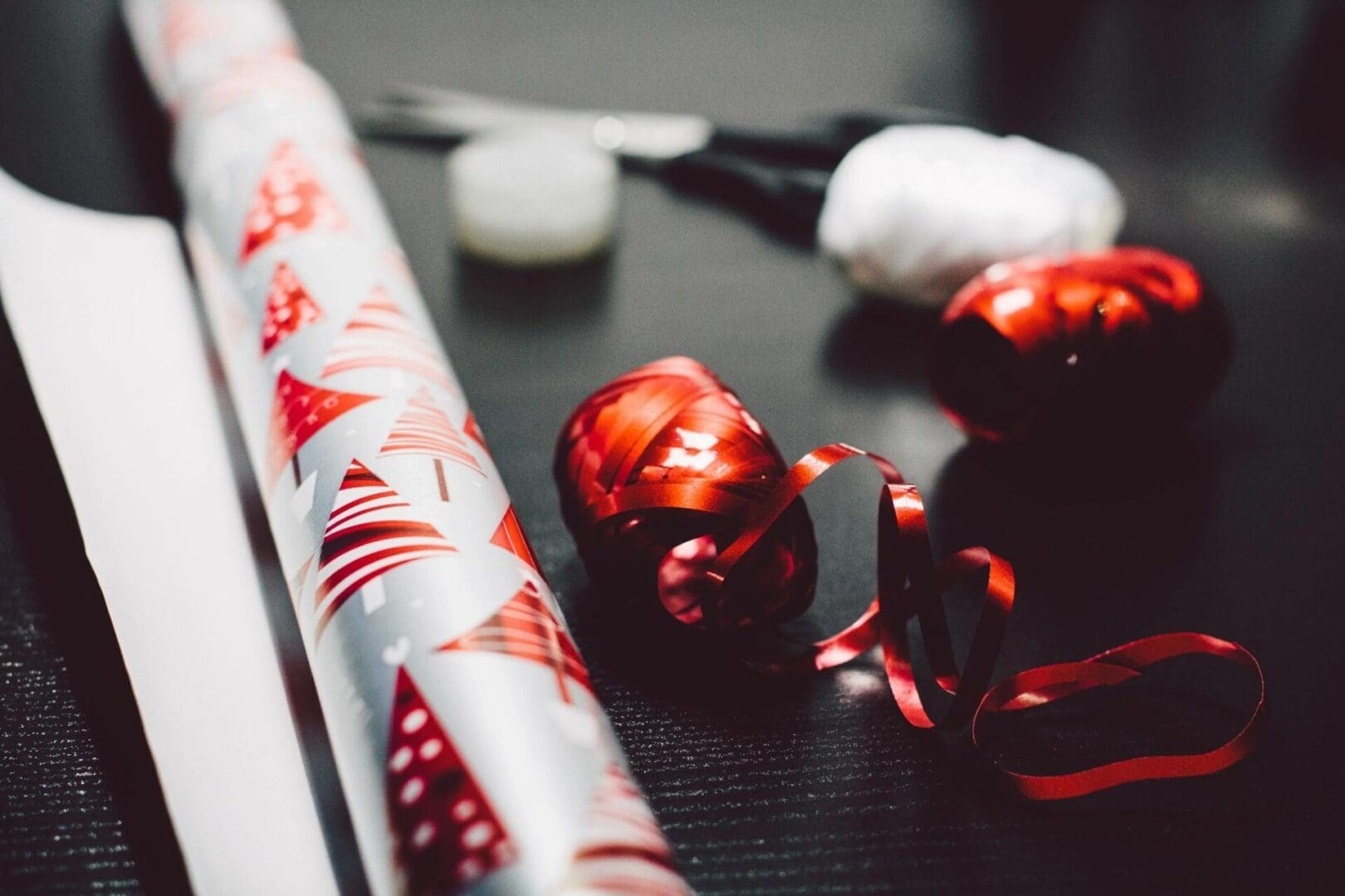 A table with wrapping paper and christmas ornaments.