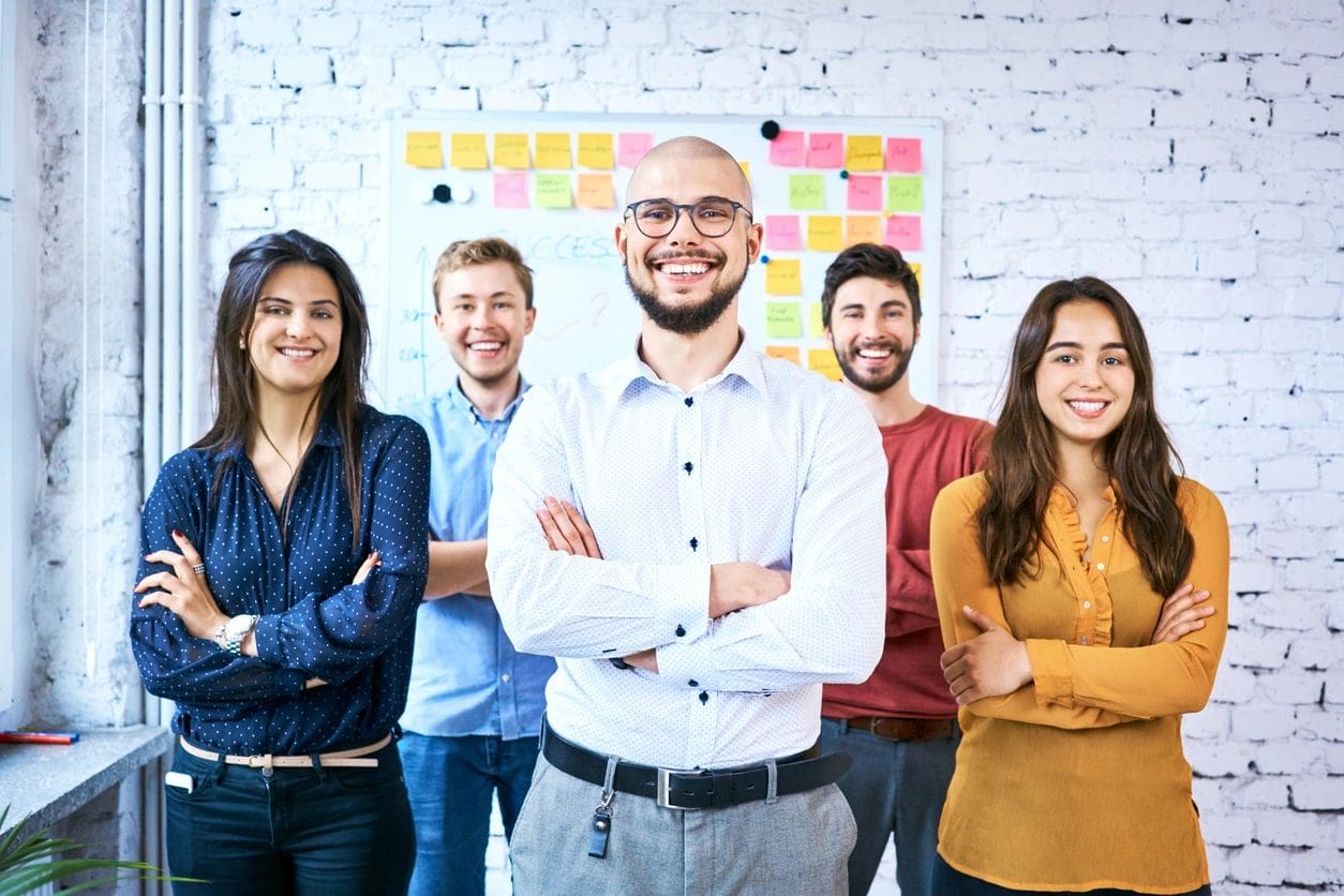 A group of people standing in front of a wall.