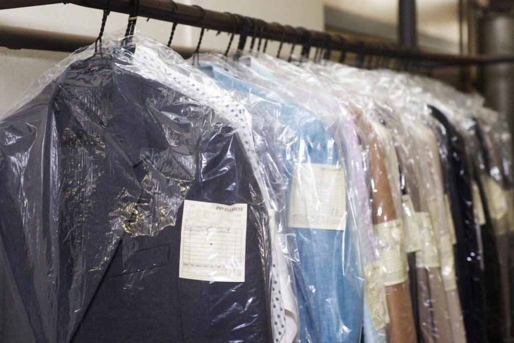 A rack of suits hanging in the closet