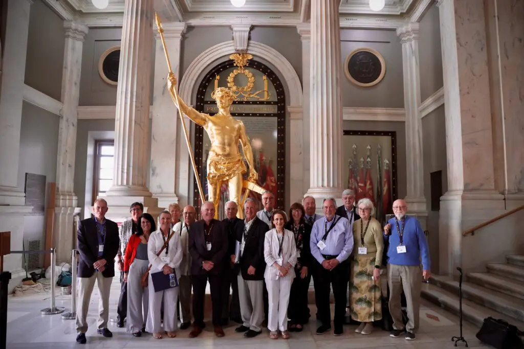 A group of people standing in front of a statue.