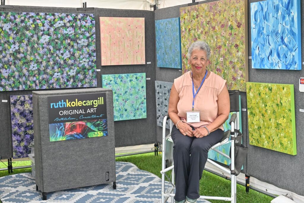 A woman sitting in front of several fabric samples.