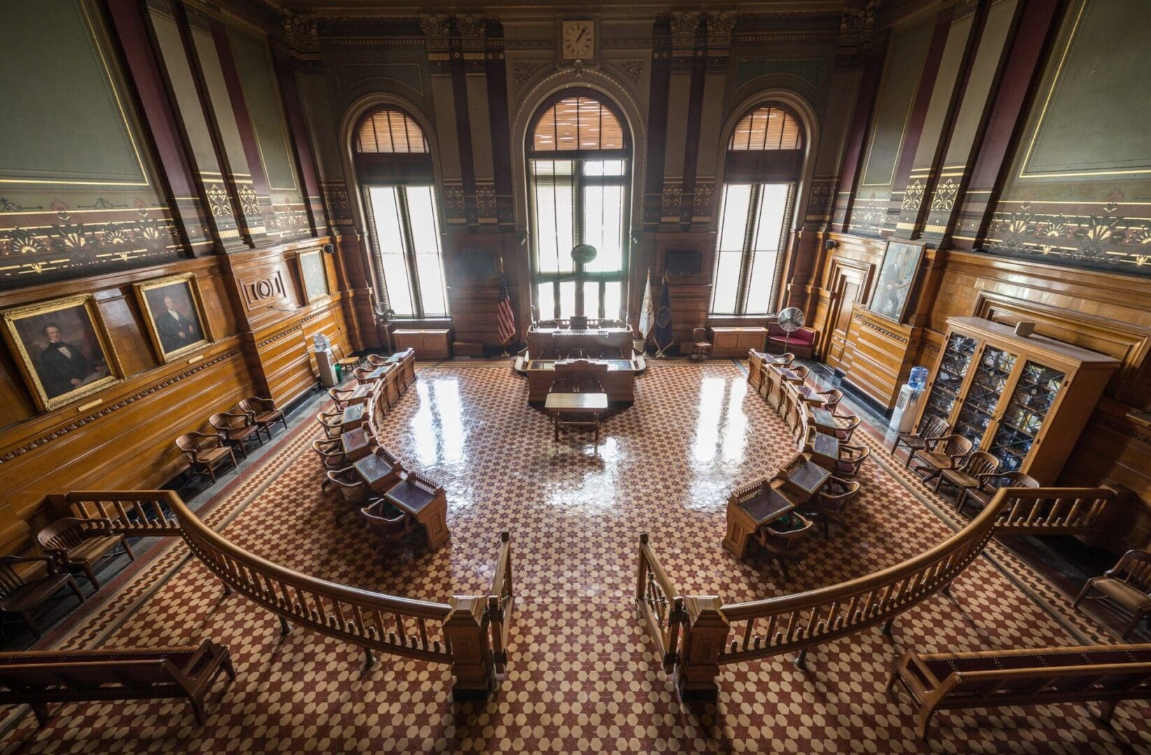 A large room with many windows and wooden floors.