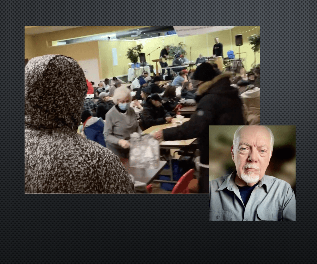 A man in a crowd of people with a person wearing a hood.