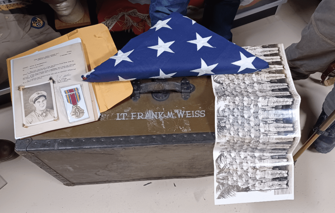 A blue flag with white stars on it next to a box of papers.