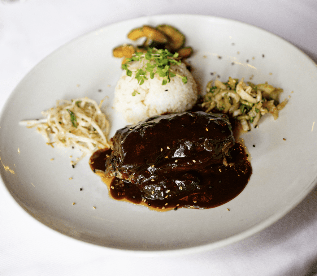 A plate of food with rice and meat on it.