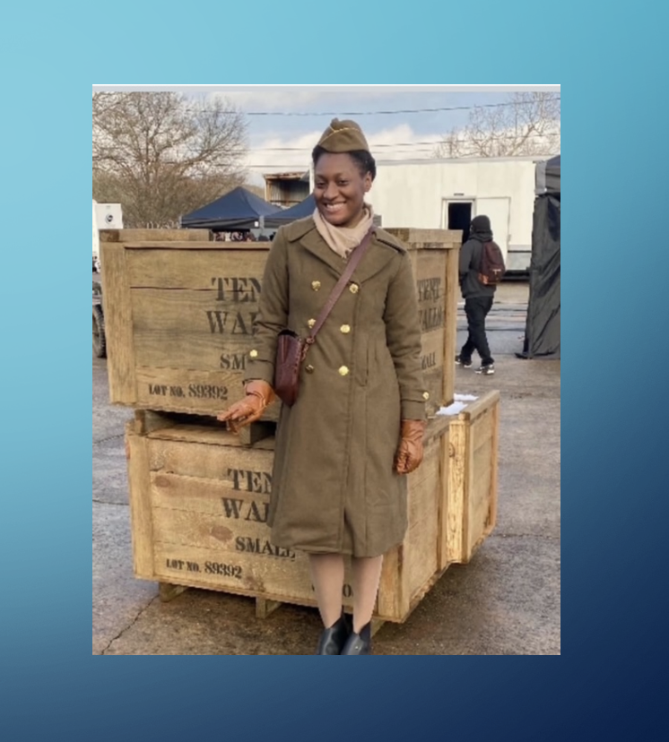 A woman in military clothing standing next to boxes.