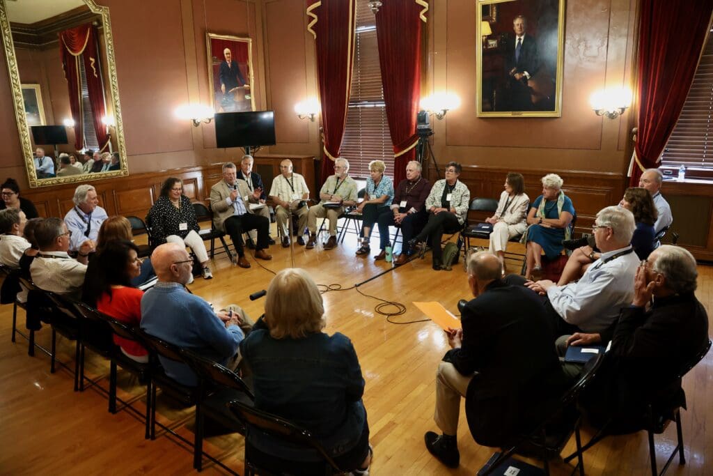 A group of people sitting in chairs around each other.