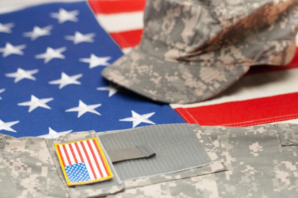 A soldier 's hat and flag on the ground.