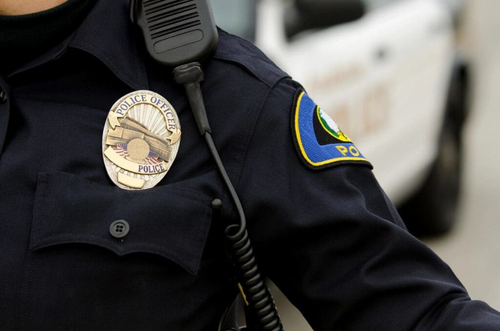 A police officer is wearing his uniform and badge.