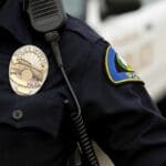 A police officer is wearing his uniform and badge.