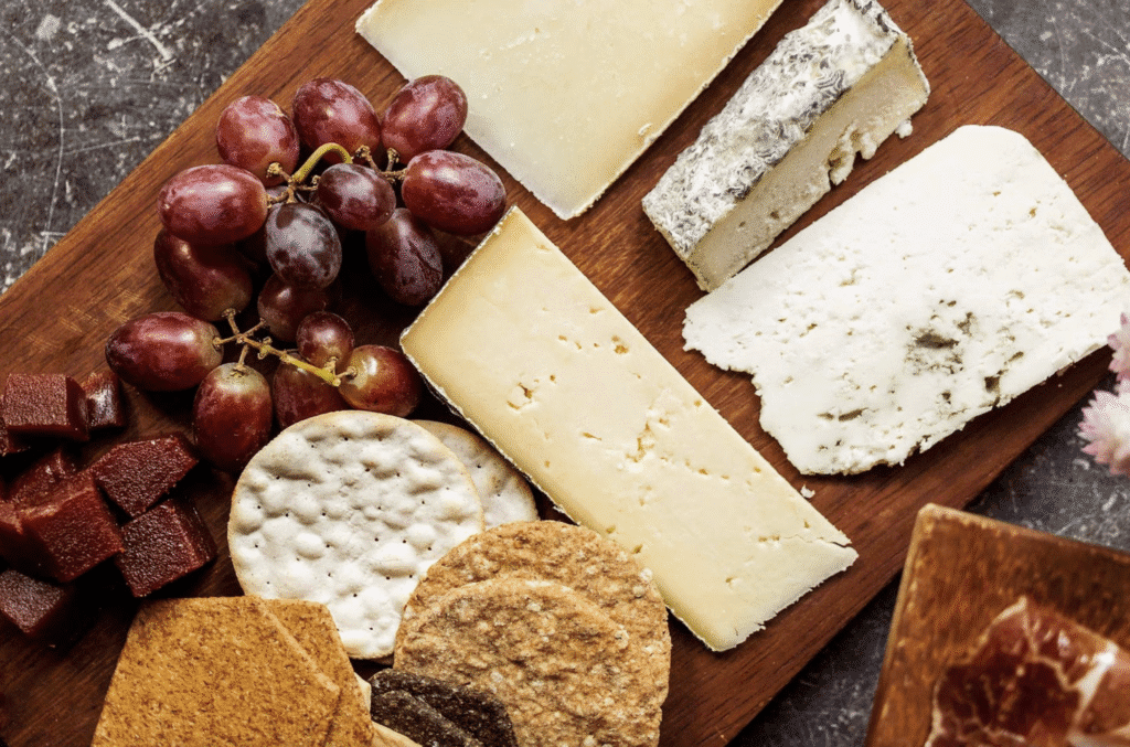 A wooden board with cheese and crackers on it