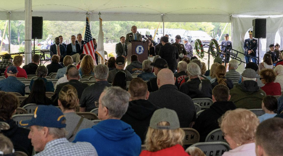 A crowd of people sitting in chairs and standing around.