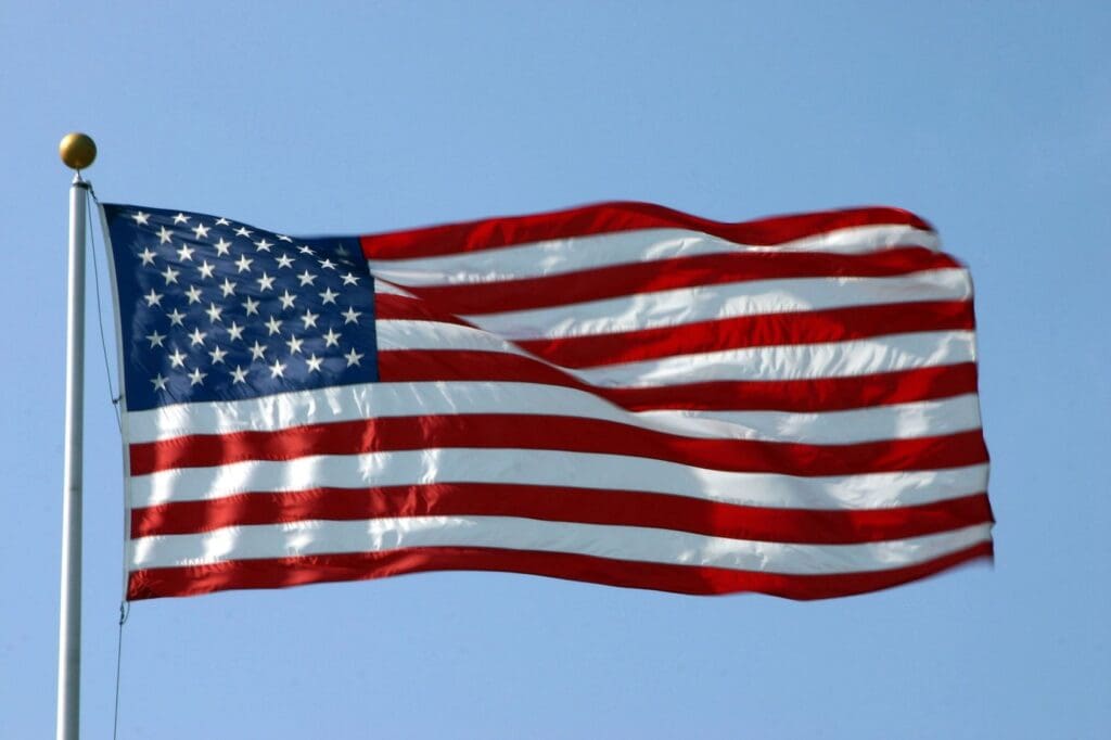 A flag flying in the sky on a sunny day.