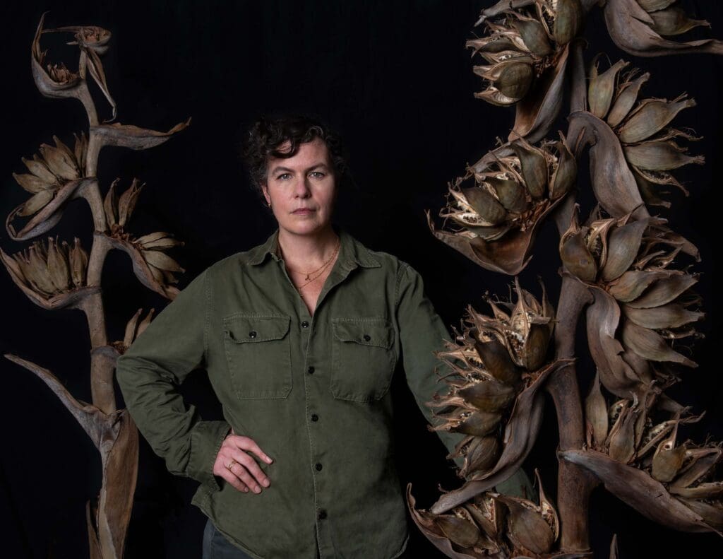 A woman standing in front of some plants