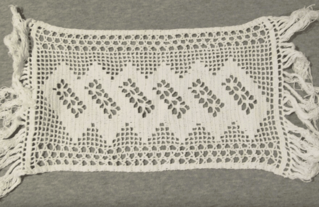 A white lace trim with a pattern of leaves.