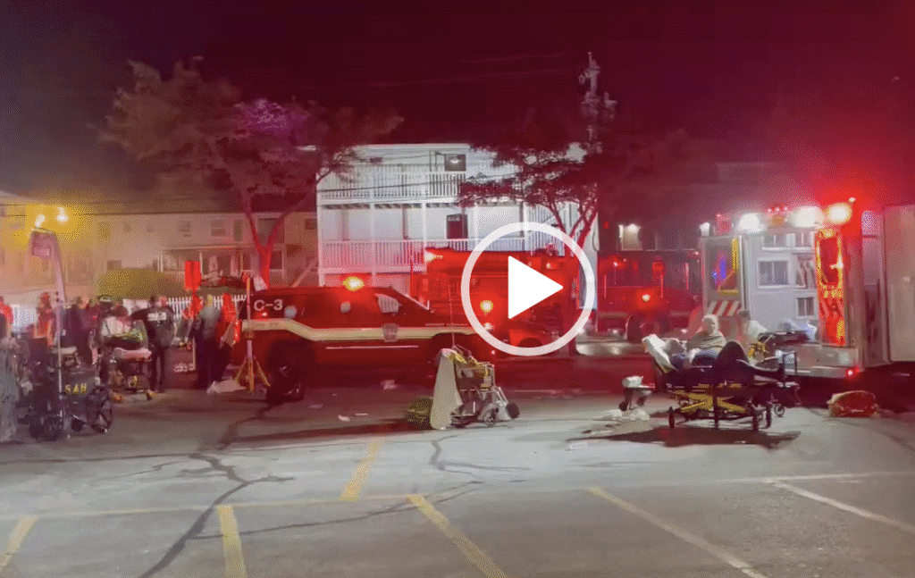 Emergency responders at a nighttime accident scene with a train and injured people.