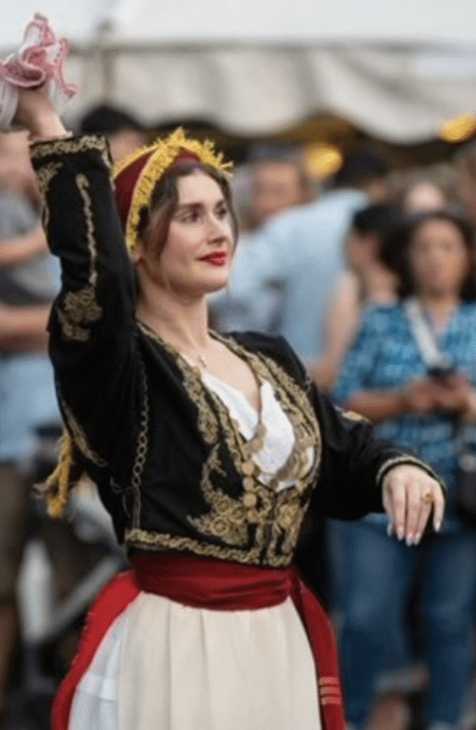 Woman in traditional dress raising her arm during an event.