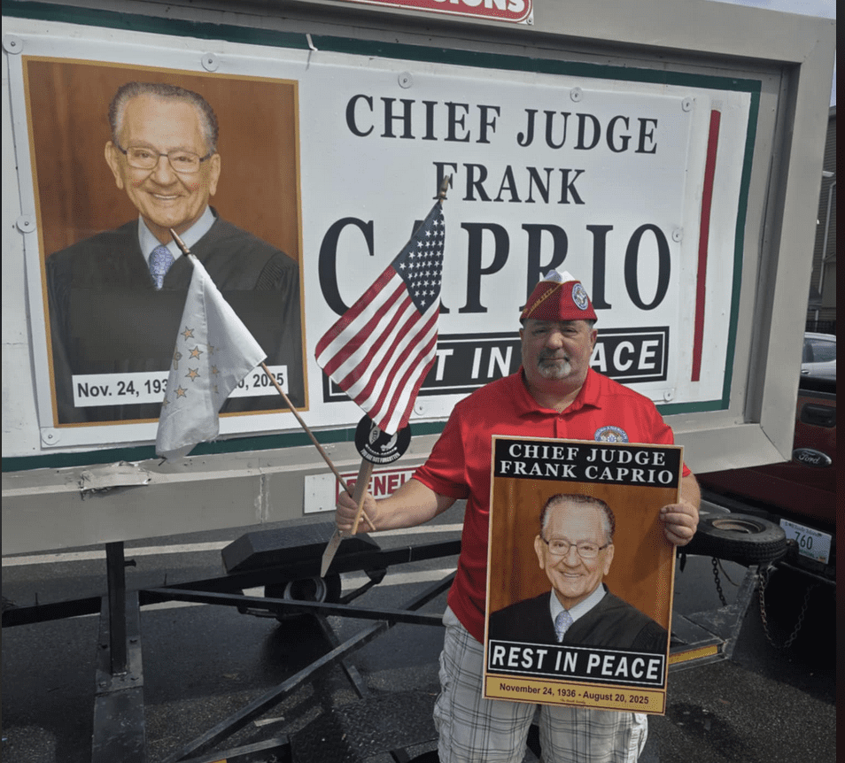 A man holding a sign honoring Chief Judge Frank Caprio.