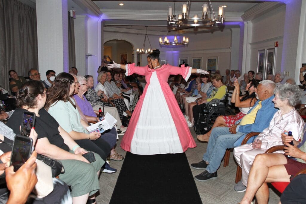 Model showcasing a traditional outfit on a runway.