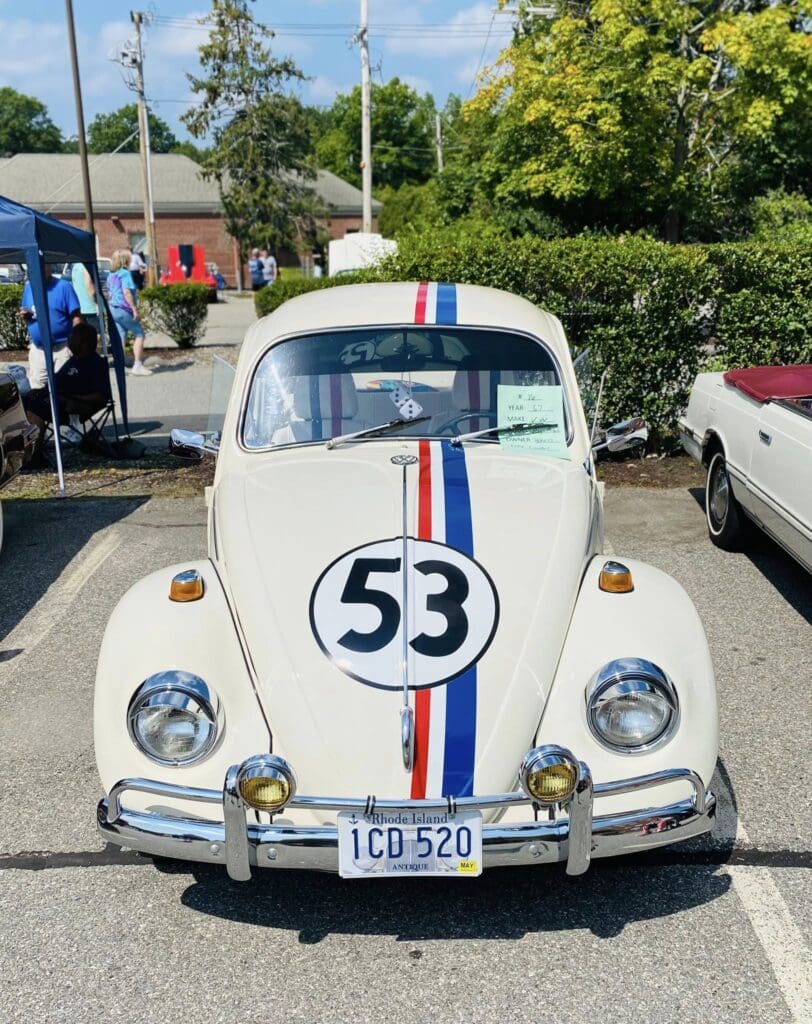Classic white Volkswagen Beetle with racing stripes and number 53.