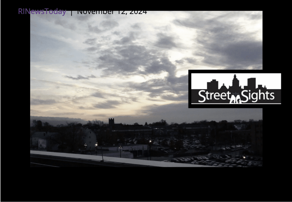 Cityscape at dusk with cloudy skies and silhouetted buildings.