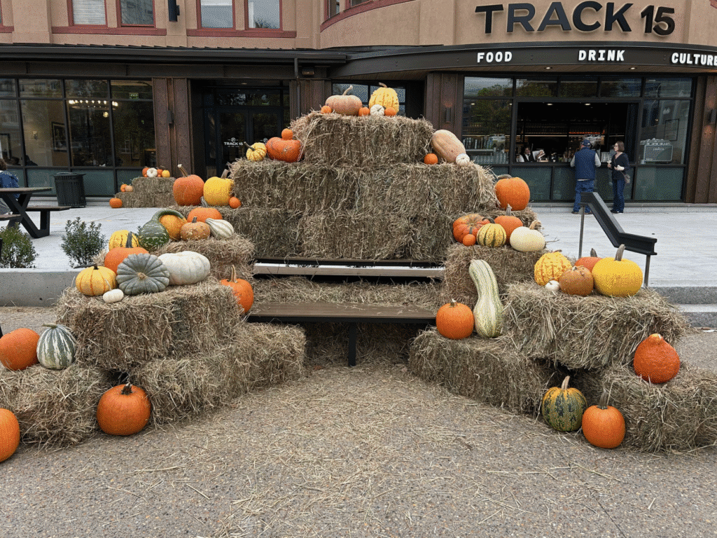 Autumn display with pumpkins and hay bales outside a restaurant.