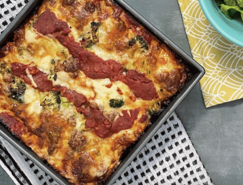 Freshly baked lasagna with melted cheese and tomato sauce in a baking tray.