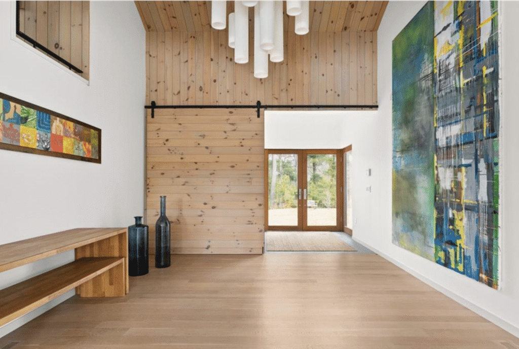 Minimalist room with wooden walls, floor, and modern ceiling lights.