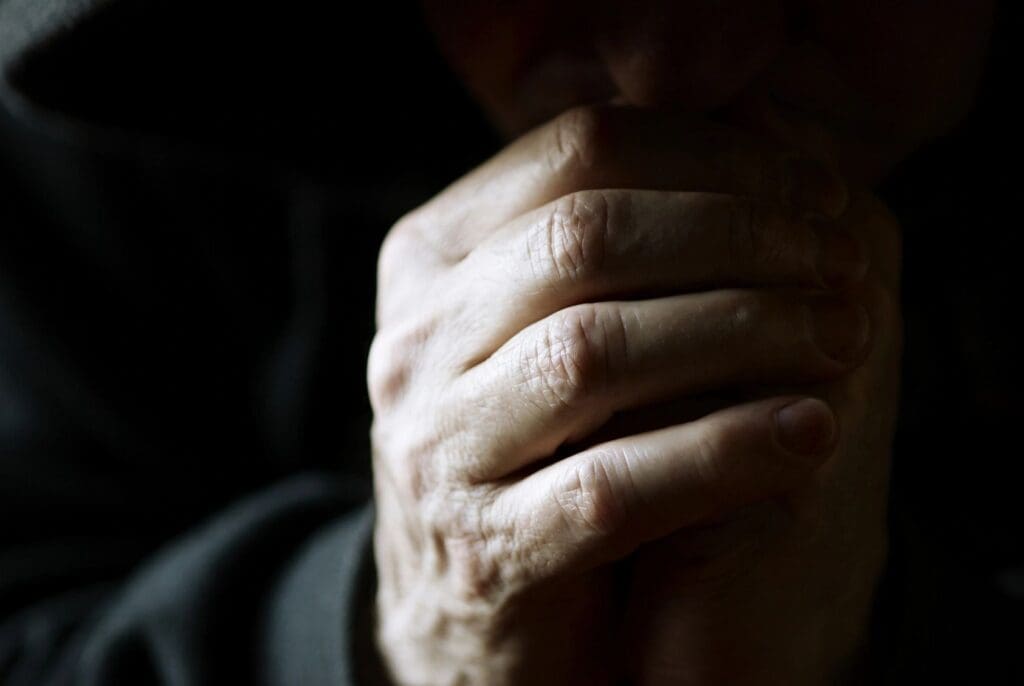 Close-up of a hand with visible wrinkles in soft lighting.