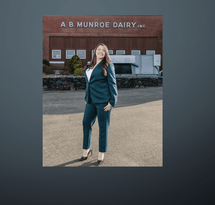 Woman in teal suit standing outdoors in front of a building.