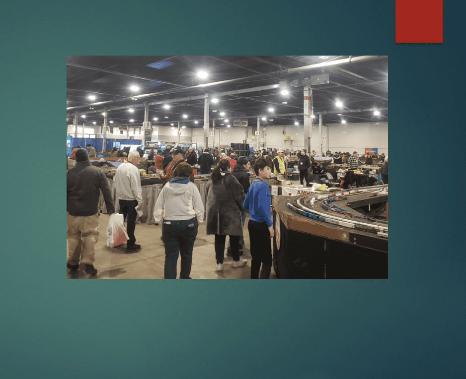 People explore a large indoor market filled with various goods and bright overhead lights.