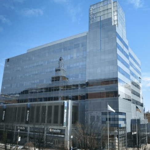Modern glass office building reflecting the sky.