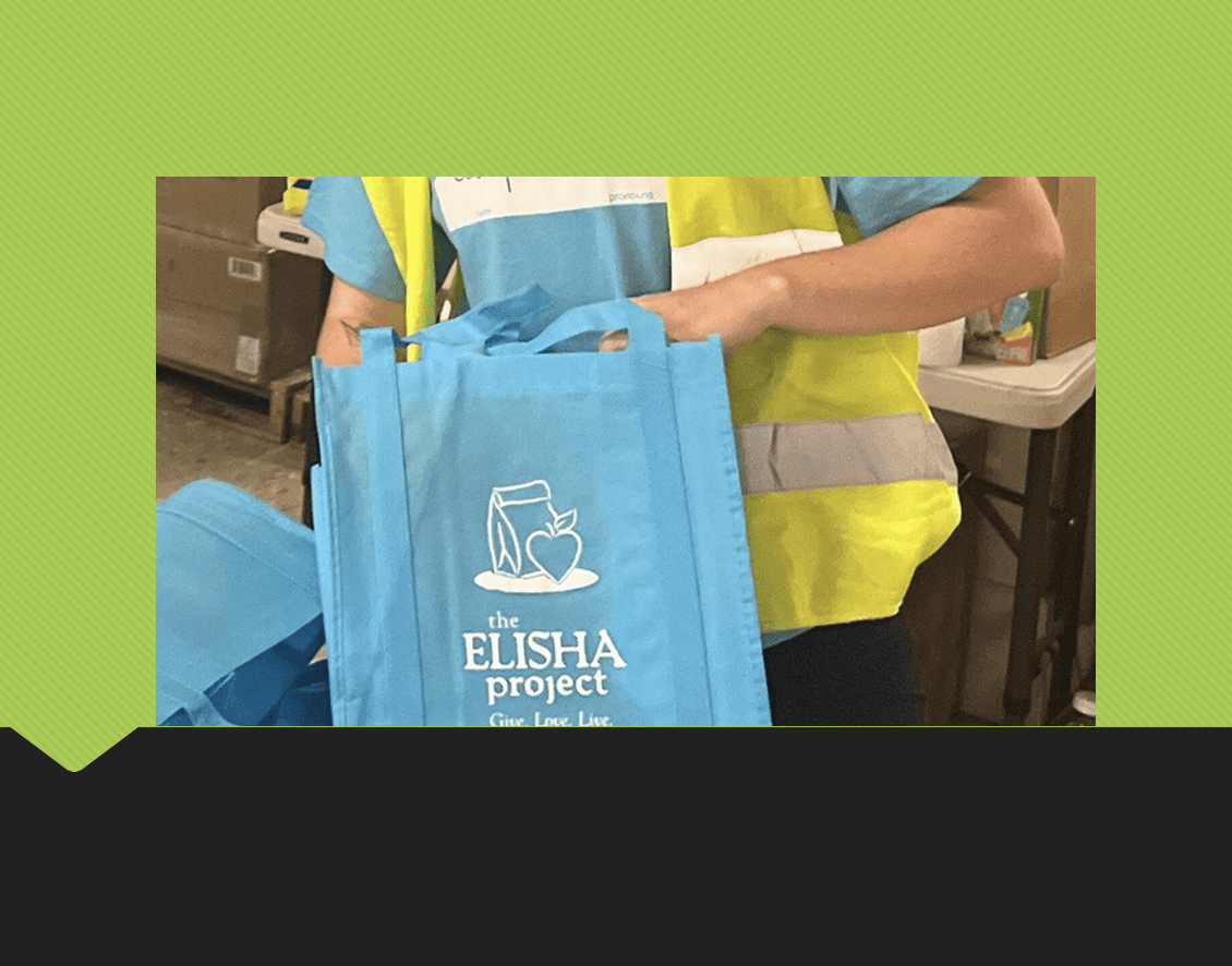 Cars line up at a drive-through food and essentials distribution hosted by The Elisha Project in Pawtucket