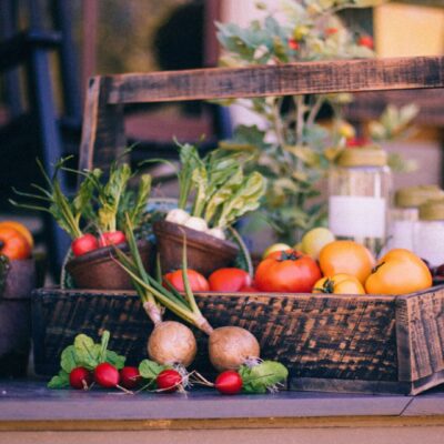 A basket of fruit and vegetables on top of a table.