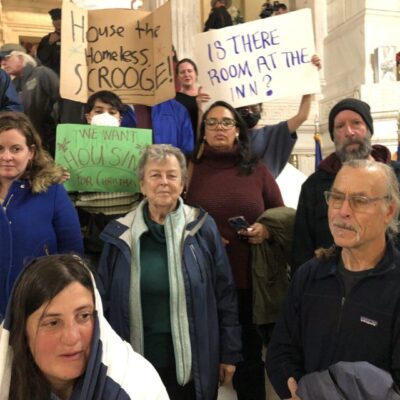 A group of people holding signs in front of a building.