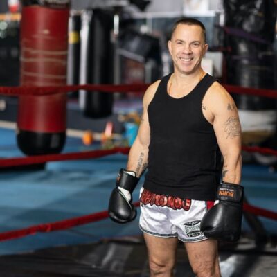 Smiling boxer in boxing gloves and shorts.