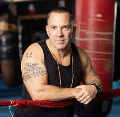 Here's an alt tag for the image: `Mark Wahlberg, boxing gym portrait`