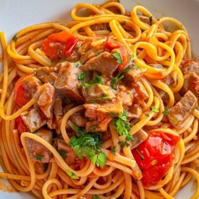 Plate of spaghetti with tomato sauce, mushrooms, and herbs.