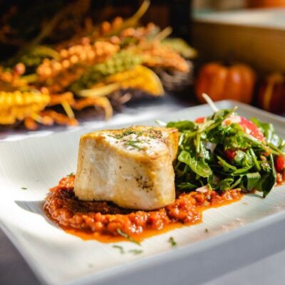 A plate of fish and vegetables on a table, perfect for healthy recipes.