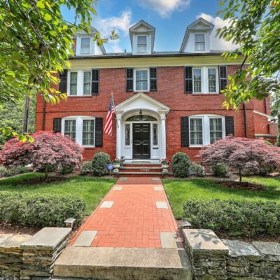 Brick colonial house with American flag.