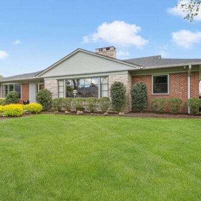 Brick ranch house with green lawn.