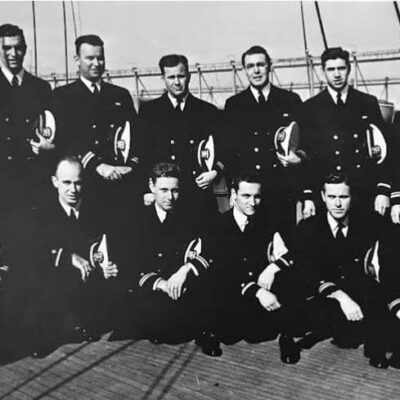 A group of men in navy uniforms posing for a photo.