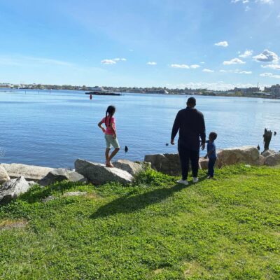 A group of people standing near a body of water.